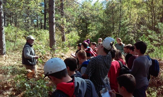 Merle Ring leading a forestry lesson for a group of students at the Demo Forest