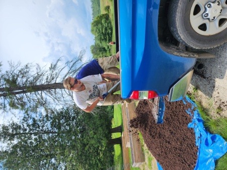 Volunteer Jamie Bryant of New Sharon and entrepreneur Michael Neumann of Phillips shoveling compost donated by the Farmington Compost Program at UMF.