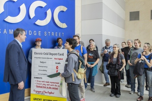 Scorecard Delivery to MA Officials May 2025 Activists deliver a scorecard to MA state officials regarding the governance of the regional electric grid