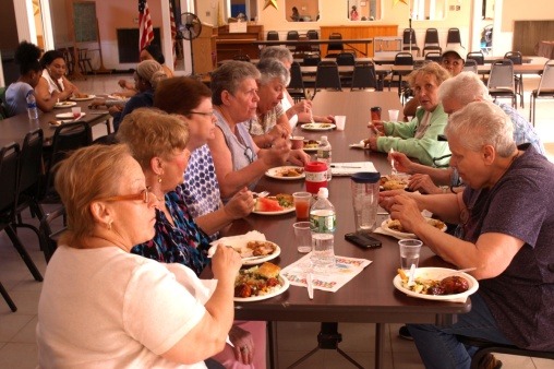 Participants enjoying conversation and food at potluck celebrating first calendar production