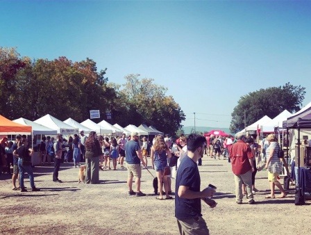 Customers enjoy a sunny day at the farmers market.