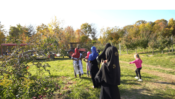 A group of enthusiastic kids set off for a delightful day of apple picking, eager to connect with their community and share in the joy of the harvest.