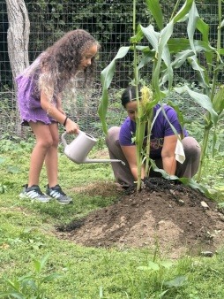 Attaquis Pocknett and daughter Hazel water the garden August 2025
