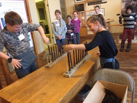 Students playing a bobbin game during a visit to the Mill Museum for experiential learning Students playing a bobbin game during a visit to the Mill Museum