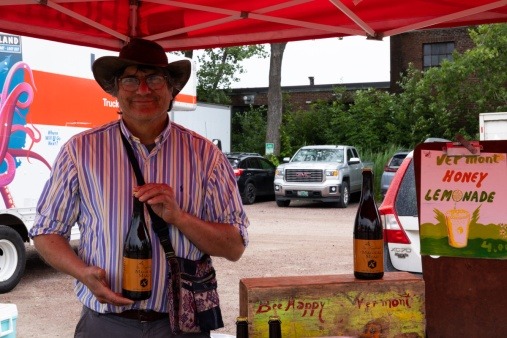 Pedro Salas from Bee Happy VT holding up a bottle of mead