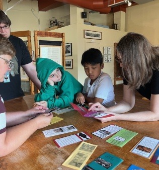 Elementary school students looking at pamphlets about current global labor issues Elementary school students looking at pamphlets about current global labor issues