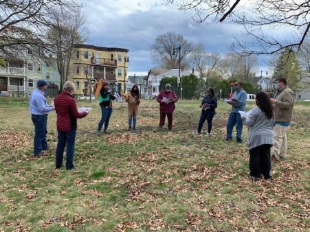 Group of 9 people outside facing each other in a circle