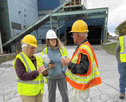 DWME members tour Eagle Point Energy 3 people in safety vests and hard hads at a wate to energy plant