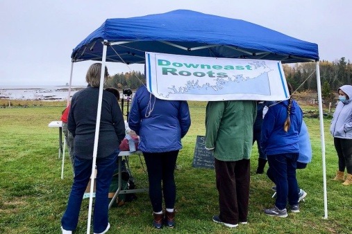 People standing under a tent awning