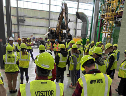 DWME on Hampden tour of Municiple Waste Hub Vistitors in safety vests and hard hats at a recycling facility
