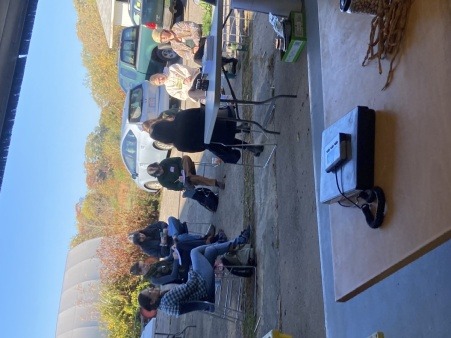 Farmers sitting outside in a half circle at URI, learning basic herbal first aid