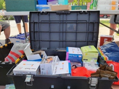 Black rectangular tote containing new syringes, intramuscular narcan, and fentanyl test strips