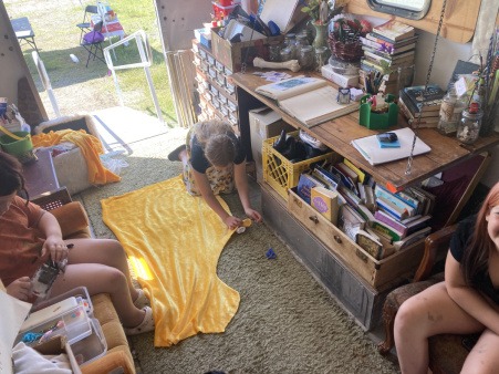 A photo taken from above of youth spending time inside the Joy Truck working on sewing designs.
