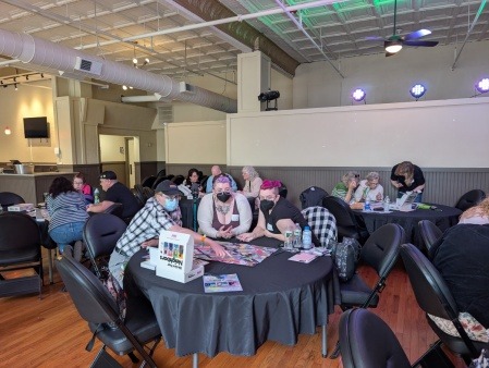 Participants play Queerlective's community board game: We Are Your Neighbors