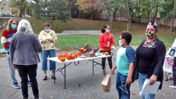 Community Health Workers tabling at the Harvest Festival and handing out free pumpkins for visitors