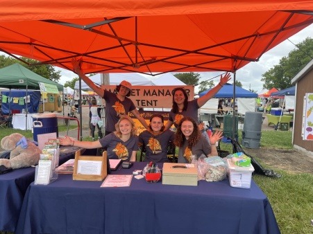 staff and volunteers pose happily at the manager tent of the market