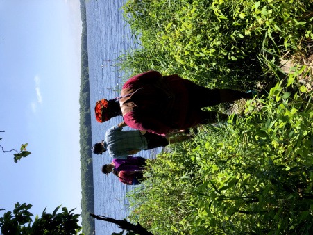 Retreat attendees walk toward a lake through an overgrown path