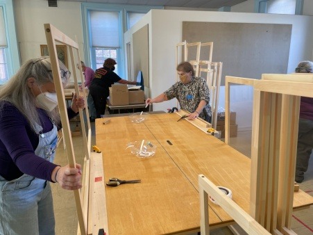 Volunteers assembling inside storm windows, 2021