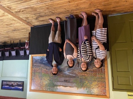 Four Asian Americans standing indoors at restaurant
