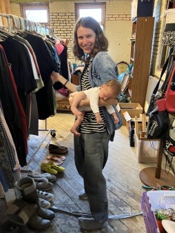 a parent shopping with a baby in one arm at the hope st free store