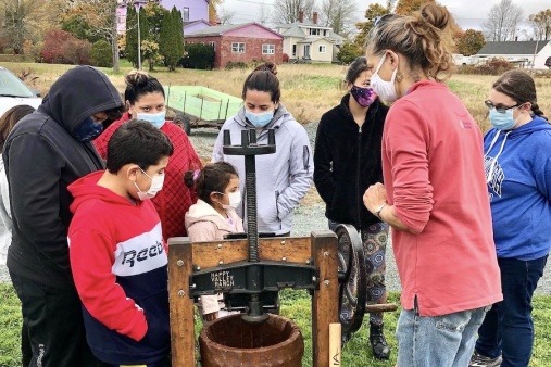 Family learning how to press cider