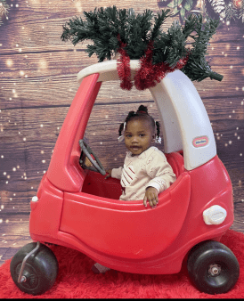 A learning center child enjoys her new car