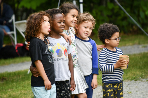 Group young persons of color, appearing to pose for a different camera.