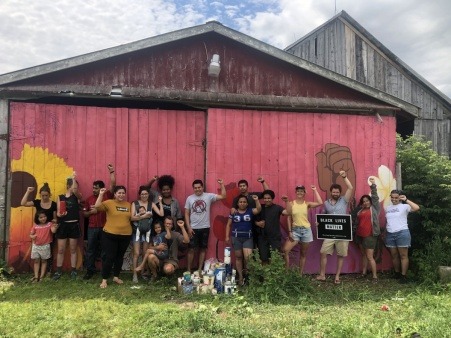 Migrant Justice Members work on a Collaborative Mural with the Northstar Collective during their annual retreat at the Grassroots Center