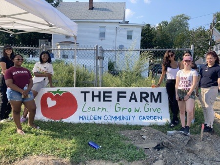 Teens from Malden Teens Enrichment Center Standing by the Sign They Made for The Farm at Malden Community Garden.