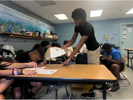Youth participating in a Sin-cere Multiservice Inc. financial literacy activity, engaging in hands-on learning designed to build money management and entrepreneurship skills.