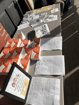 Clean Air Club's table at the Barre Queer Craft Fair displays free respirators and boxes of COVID tests as well as information and zines. 