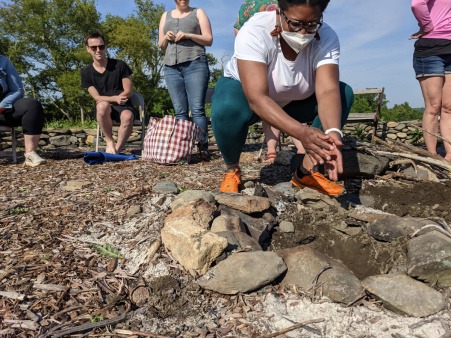A retreat participant engages in a ritual of digging up what was buried there in previous seasons