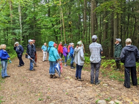 Carroll County legislators, officials, and non-profits gather in the forest to watch a demonstration by Tin Mountain Conservation Center