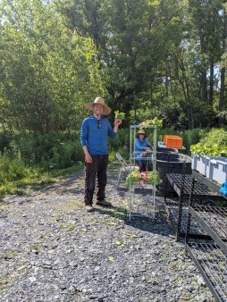 Farm manager Charlie Watt and AmeriCorps member Jen Ireland celebrate the first radish harvest of the 2023 season. 
