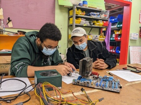 Two people work on building a personal computer together