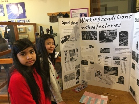 Two middle school students with their poster presentation about labor issues in the shoe industry. Two middle school students with their poster presentation about labor issues in the shoe industry.