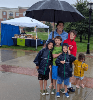 A family of 5 attending the market in a full blown rain storm