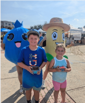 Children at the market showing off the fruit they bought with their POP Club money for the weewk