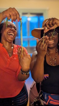 Tiny carrots are held up by two retreat facilitators