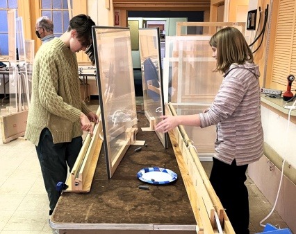 Volunteers assembling inside storm windows, 2024