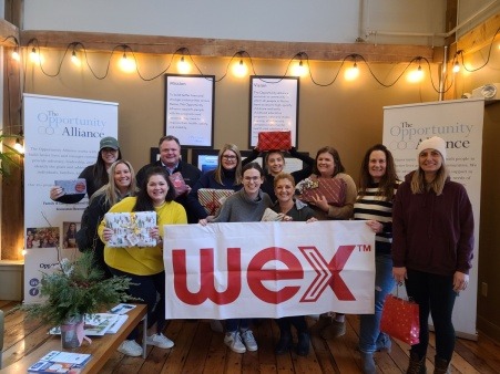 Employees of WEX, Inc. gather in the TOA lobby to distribute holiday gifts to our clients.