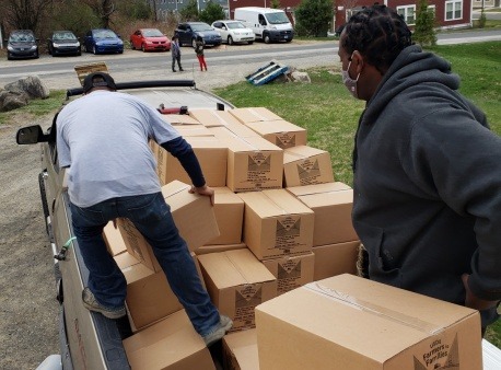 volunteers loading boxes of food into a pickup truck